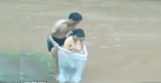 Niños cruzan un río en una bolsa de plástico para ir a la escuela