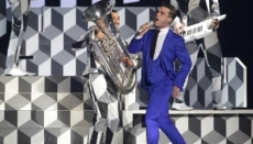 Robbie Williams tropieza durante concierto y le fractura brazo a una fan.